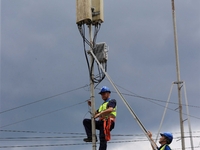 A staff member is repairing a damaged communication base station in Si 'an village, Rongan county, Liuzhou city, South China's Guangxi Zhuan...