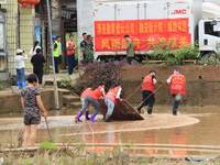 Volunteers are cleaning up silt in Si 'an village, Rongan county, Liuzhou city, South China's Guangxi Zhuang Autonomous region, in Liuzhou,...