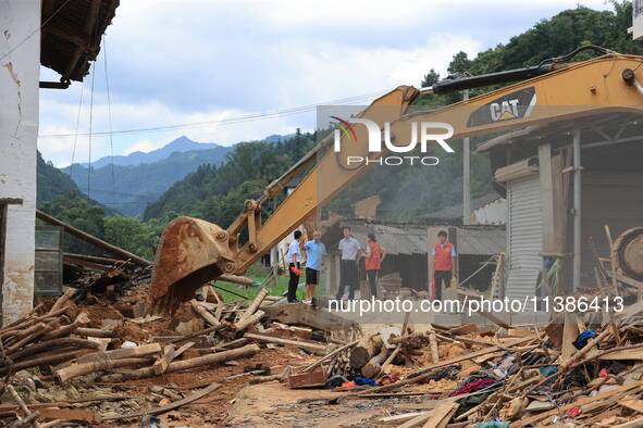 Workers are cleaning up collapsed houses in Si'an village, Rongan county, Liuzhou city, South China's Guangxi Zhuang Autonomous region, in L...