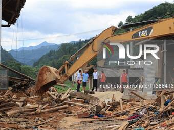 Workers are cleaning up collapsed houses in Si'an village, Rongan county, Liuzhou city, South China's Guangxi Zhuang Autonomous region, in L...