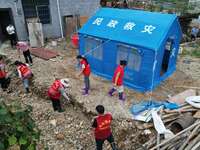 A worker is setting up tents for villagers in Si'an village, Rongan county, Liuzhou, China, on July 5, 2024. (