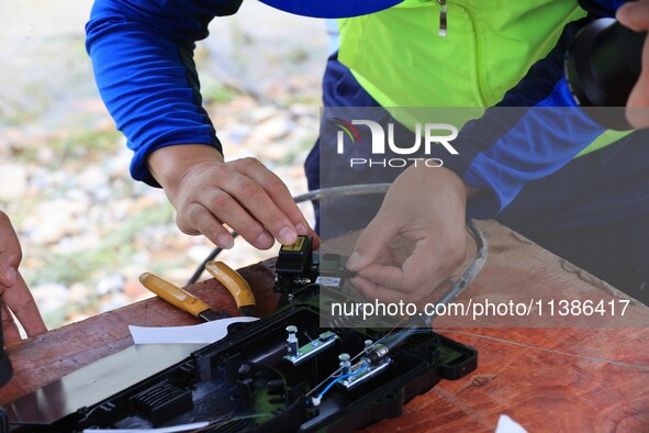 A staff member is repairing a damaged communication base station in Si 'an village, Rongan county, Liuzhou city, South China's Guangxi Zhuan...