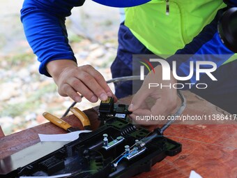 A staff member is repairing a damaged communication base station in Si 'an village, Rongan county, Liuzhou city, South China's Guangxi Zhuan...