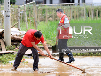 Volunteers are cleaning up silt in Si 'an village, Rongan county, Liuzhou city, South China's Guangxi Zhuang Autonomous region, in Liuzhou,...