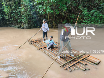 Tourists from Shanghai are walking through the rain forest with their children in the Jinuo Mountain rain forest in Xishuangbanna city, Yunn...