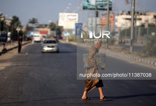 A displaced Palestinian man is walking on Salah al-Din Street in Deir el-Balah in the central Gaza Strip on July 6, 2024, amid the ongoing c...