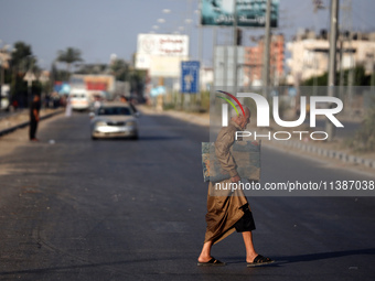 A displaced Palestinian man is walking on Salah al-Din Street in Deir el-Balah in the central Gaza Strip on July 6, 2024, amid the ongoing c...