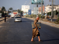 A displaced Palestinian man is walking on Salah al-Din Street in Deir el-Balah in the central Gaza Strip on July 6, 2024, amid the ongoing c...