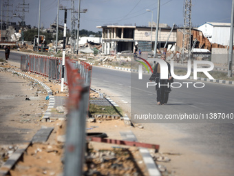 A displaced Palestinian woman is walking on Salah al-Din Street in Deir el-Balah in the central Gaza Strip on July 6, 2024, amid the ongoing...