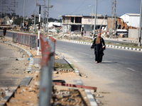 A displaced Palestinian woman is walking on Salah al-Din Street in Deir el-Balah in the central Gaza Strip on July 6, 2024, amid the ongoing...