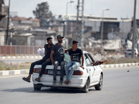 Palestinian men are sitting behind a car on Salah al-Din Street in Deir el-Balah in the central Gaza Strip on July 6, 2024, amid the ongoing...