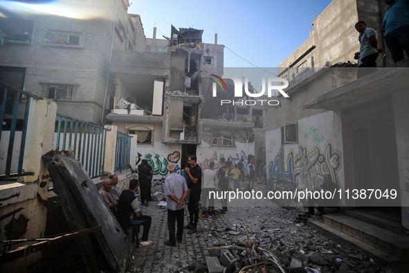 Palestinians are checking the destruction after an Israeli strike the previous day on a house in the Nuseirat refugee camp in the central Ga...