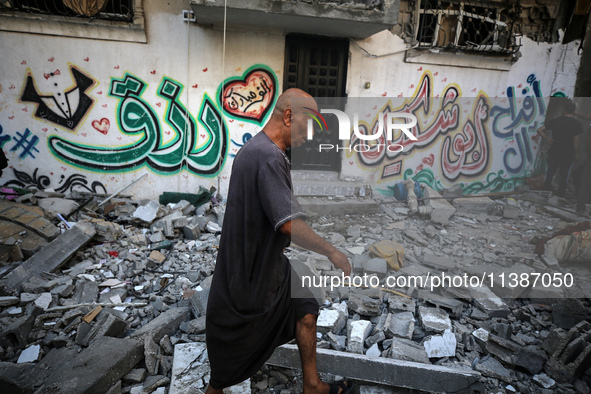 Palestinians are checking the destruction after an Israeli strike the previous day on a house in the Nuseirat refugee camp in the central Ga...