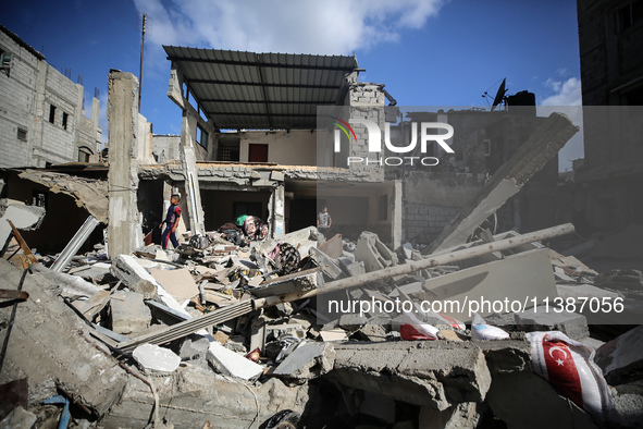 Palestinians are checking the destruction after an Israeli strike the previous day on a house in the Nuseirat refugee camp in the central Ga...