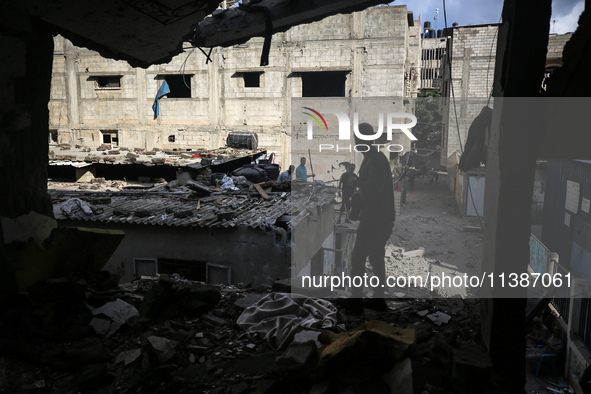 Palestinians are checking the destruction after an Israeli strike the previous day on a house in the Nuseirat refugee camp in the central Ga...