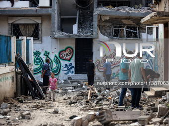 Palestinians are checking the destruction after an Israeli strike the previous day on a house in the Nuseirat refugee camp in the central Ga...