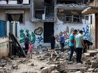 Palestinians are checking the destruction after an Israeli strike the previous day on a house in the Nuseirat refugee camp in the central Ga...