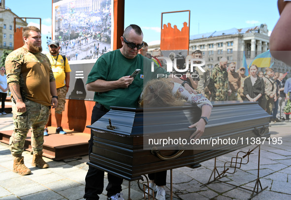 People are taking part in a funeral ceremony for British volunteer and combat medic Peter Fouche at Independence Square in Kyiv, Ukraine, on...