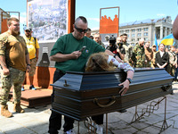 People are taking part in a funeral ceremony for British volunteer and combat medic Peter Fouche at Independence Square in Kyiv, Ukraine, on...