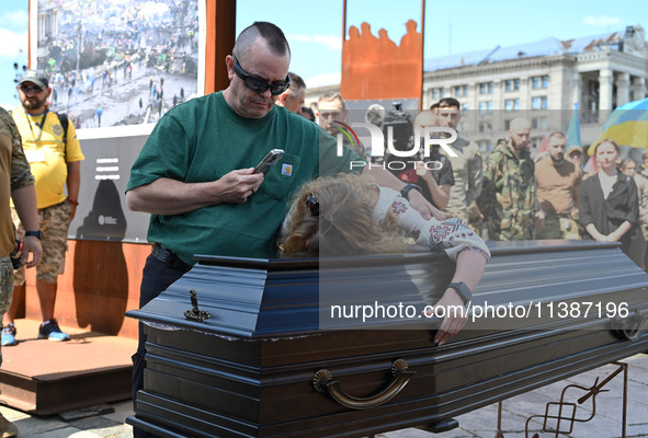 People are taking part in a funeral ceremony for British volunteer and combat medic Peter Fouche at Independence Square in Kyiv, Ukraine, on...