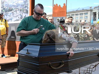 People are taking part in a funeral ceremony for British volunteer and combat medic Peter Fouche at Independence Square in Kyiv, Ukraine, on...