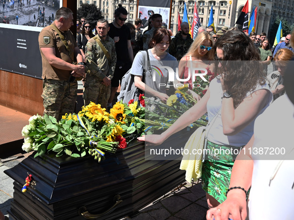 People are taking part in a funeral ceremony for British volunteer and combat medic Peter Fouche at Independence Square in Kyiv, Ukraine, on...