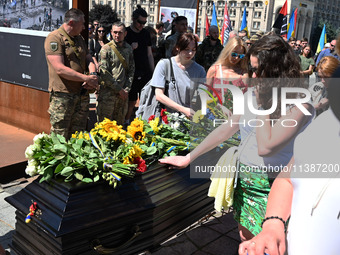 People are taking part in a funeral ceremony for British volunteer and combat medic Peter Fouche at Independence Square in Kyiv, Ukraine, on...