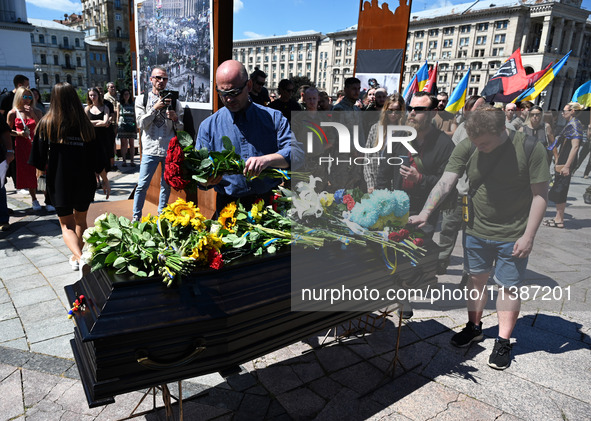 People are taking part in a funeral ceremony for British volunteer and combat medic Peter Fouche at Independence Square in Kyiv, Ukraine, on...