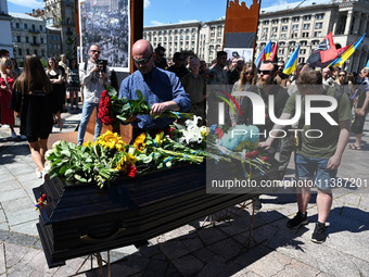 People are taking part in a funeral ceremony for British volunteer and combat medic Peter Fouche at Independence Square in Kyiv, Ukraine, on...