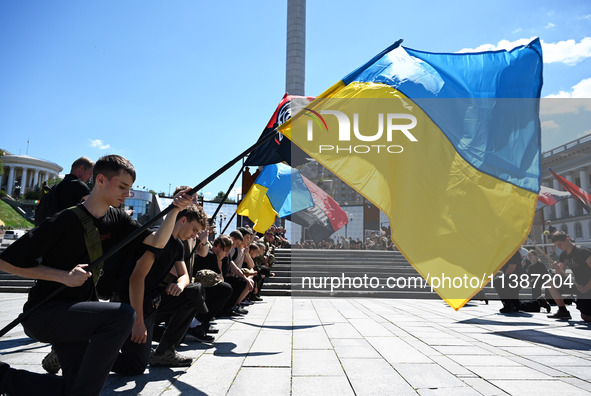 People are kneeling during a funeral ceremony for British volunteer and combat medic Peter Fouche at Independence Square in Kyiv, Ukraine, o...