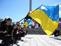 People are kneeling during a funeral ceremony for British volunteer and combat medic Peter Fouche at Independence Square in Kyiv, Ukraine, o...