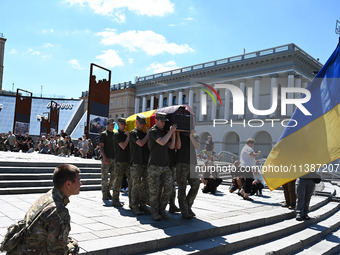 Members of the Honour Guard are carrying a coffin with the body of British volunteer and combat medic Peter Fouche during his funeral ceremo...