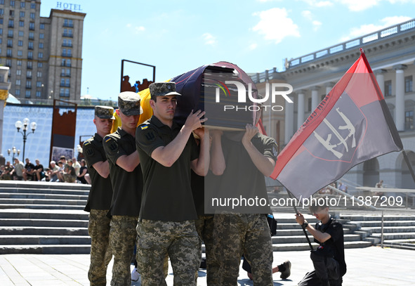 Members of the Honour Guard are carrying a coffin with the body of British volunteer and combat medic Peter Fouche during his funeral ceremo...