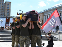 Members of the Honour Guard are carrying a coffin with the body of British volunteer and combat medic Peter Fouche during his funeral ceremo...