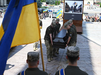 Members of the Honour Guard are carrying a coffin with the body of British volunteer and combat medic Peter Fouche during his funeral ceremo...