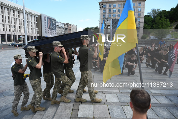 Members of the Honour Guard are carrying a coffin with the body of British volunteer and combat medic Peter Fouche during his funeral ceremo...