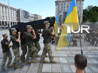 Members of the Honour Guard are carrying a coffin with the body of British volunteer and combat medic Peter Fouche during his funeral ceremo...