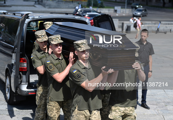 Members of the Honour Guard are carrying a coffin with the body of British volunteer and combat medic Peter Fouche during his funeral ceremo...