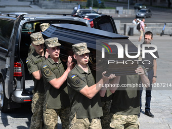 Members of the Honour Guard are carrying a coffin with the body of British volunteer and combat medic Peter Fouche during his funeral ceremo...