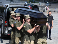 Members of the Honour Guard are carrying a coffin with the body of British volunteer and combat medic Peter Fouche during his funeral ceremo...