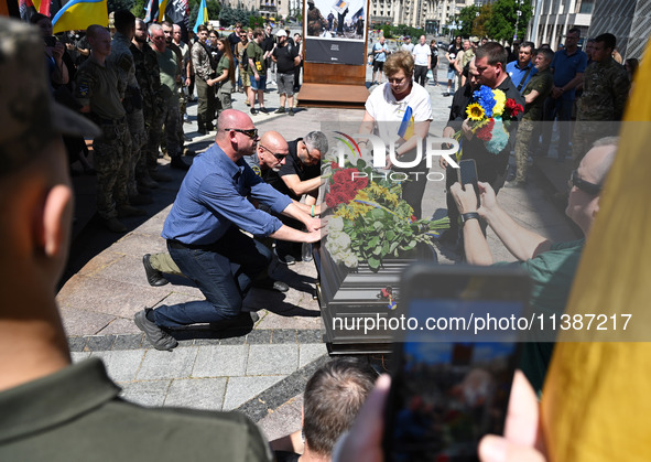 People are taking part in a funeral ceremony for British volunteer and combat medic Peter Fouche at Independence Square in Kyiv, Ukraine, on...