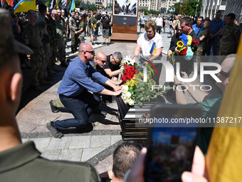 People are taking part in a funeral ceremony for British volunteer and combat medic Peter Fouche at Independence Square in Kyiv, Ukraine, on...