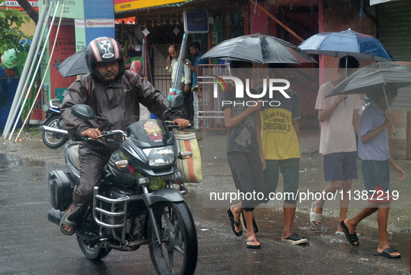 People are being seen during a continuous rainfall in Siliguri, India, on July 6, 2024. 