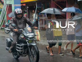 People are being seen during a continuous rainfall in Siliguri, India, on July 6, 2024. (