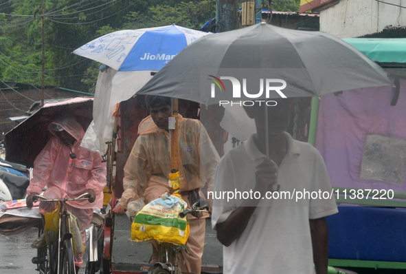 People are being seen during a continuous rainfall in Siliguri, India, on July 6, 2024. 