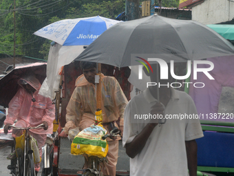 People are being seen during a continuous rainfall in Siliguri, India, on July 6, 2024. (