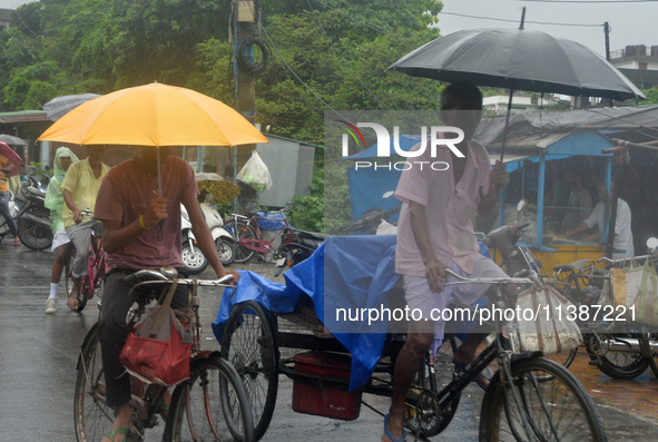 People are being seen during a continuous rainfall in Siliguri, India, on July 6, 2024. 