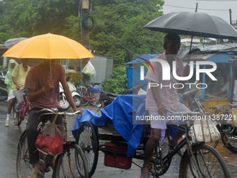 People are being seen during a continuous rainfall in Siliguri, India, on July 6, 2024. (