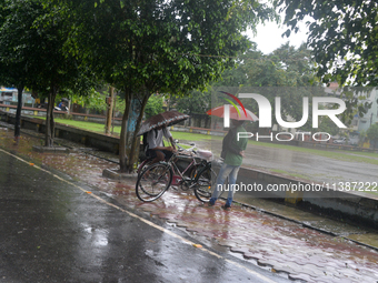 People are being seen during a continuous rainfall in Siliguri, India, on July 6, 2024. (