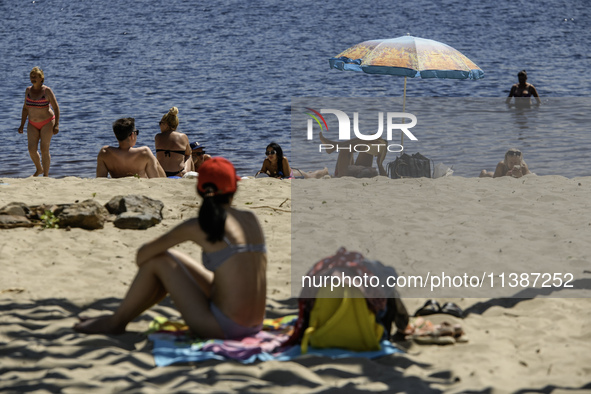 People are relaxing on the beach on the banks of the Dnipro River in Kyiv, Ukraine, on July 06, 2024. Heatwaves of up to 40 degrees Celsius...